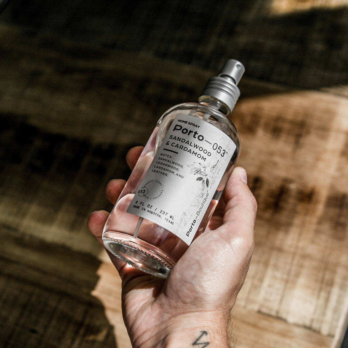 Hand holding a Porto-053 room spray bottle