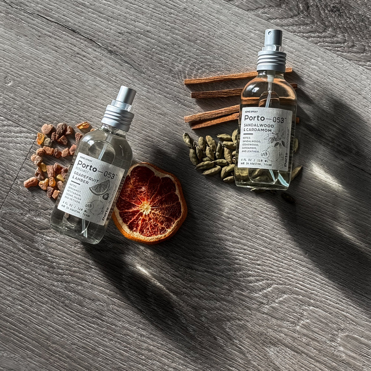 Porto-053 room spray bottles with cinnamon sticks, cardamom and dried orange on dark wood