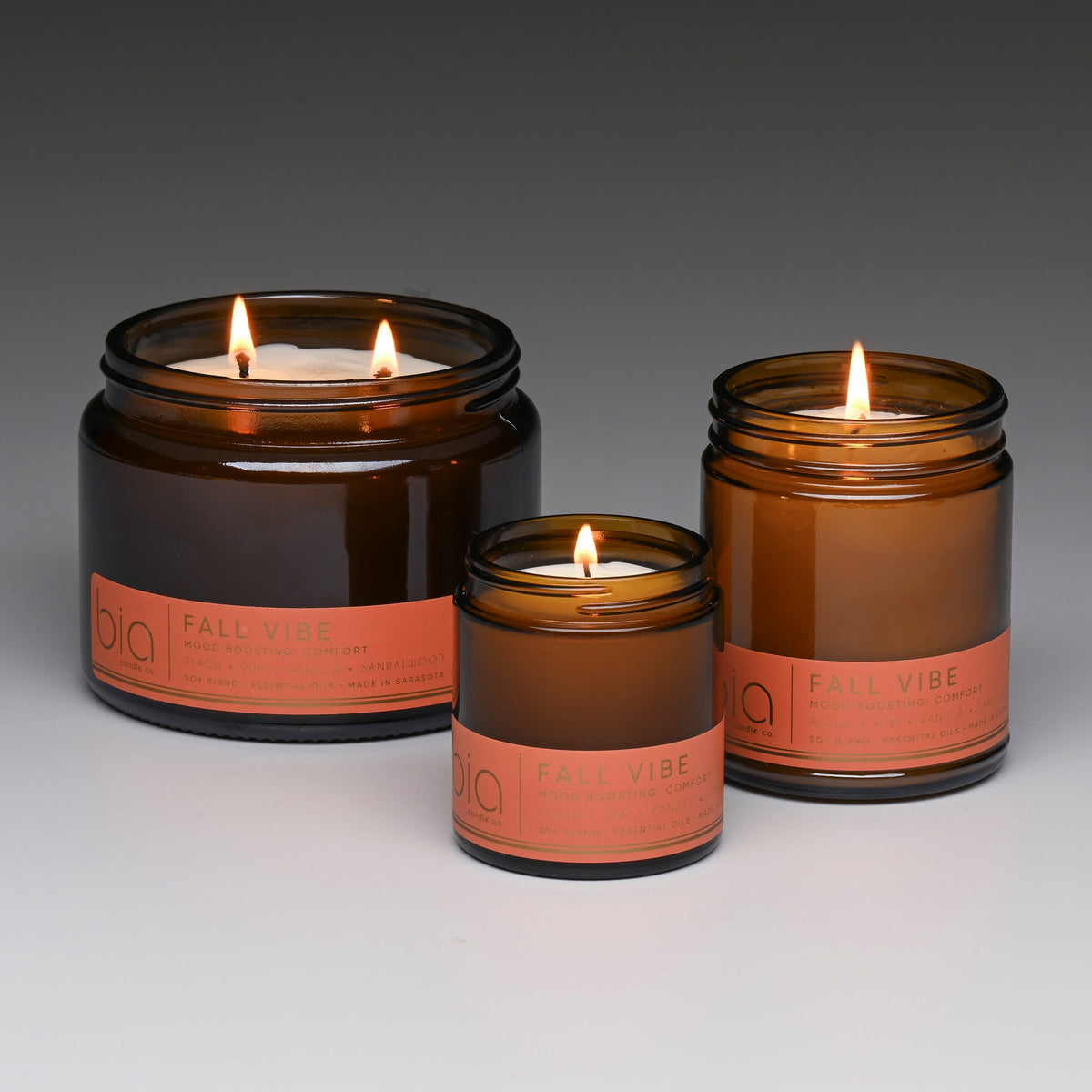 Three lit Fall Vibe candles in Grande 2-wick, Classic and Petite sizes