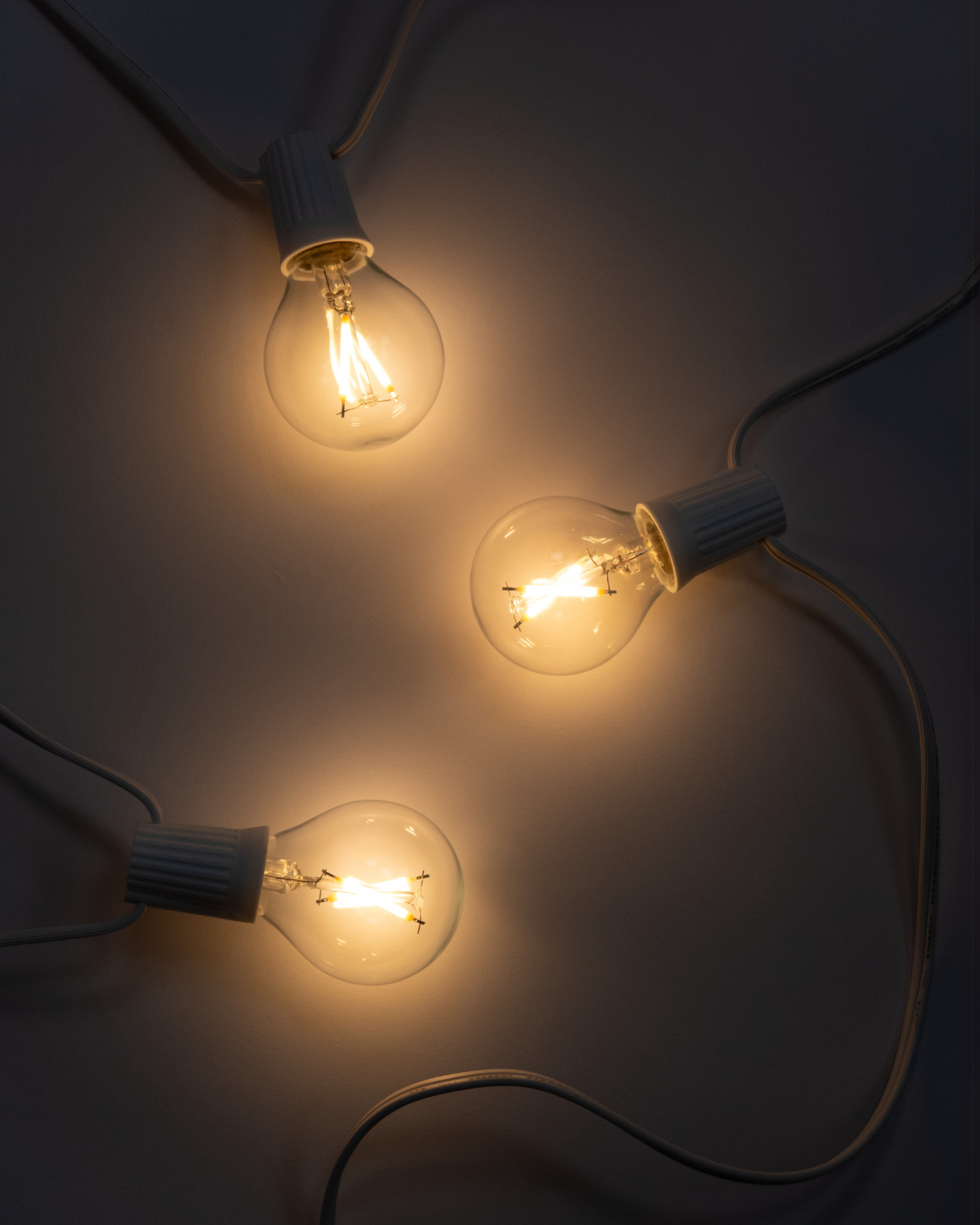 Lit Ambience Globe bulbs glowing warm white against a dark background