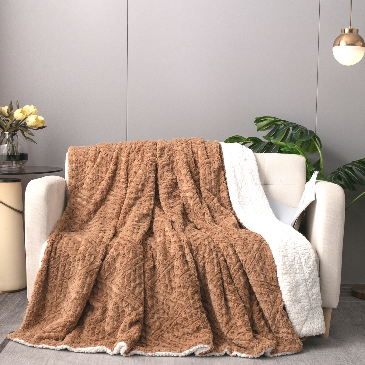 Caramel Chevron throw over a white armchair beside a potted plant