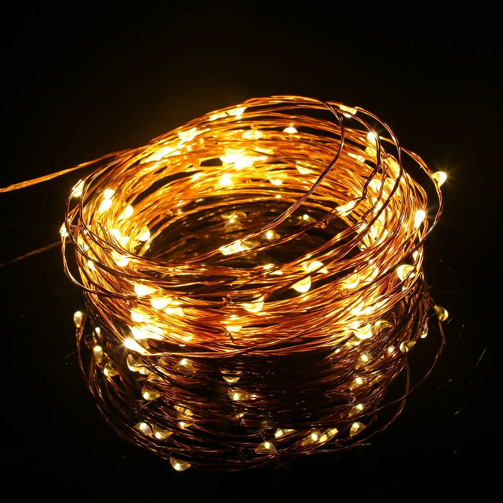 Coil of lit warm white copper wire fairy lights
