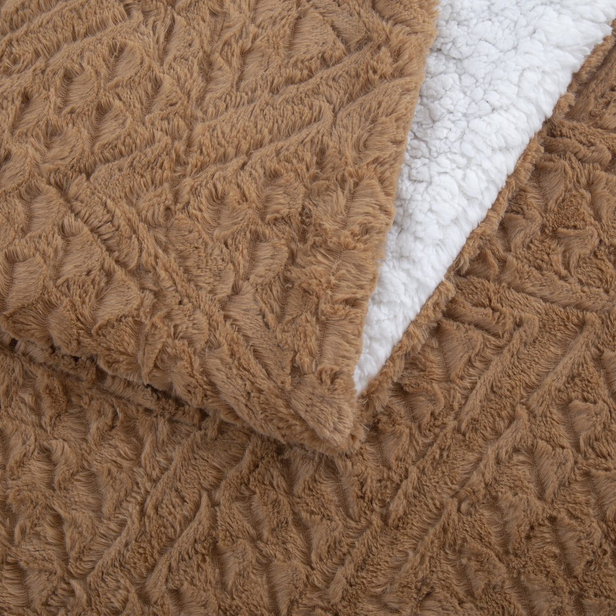 Corner of the Caramel Chevron throw folded back to show the white sherpa side