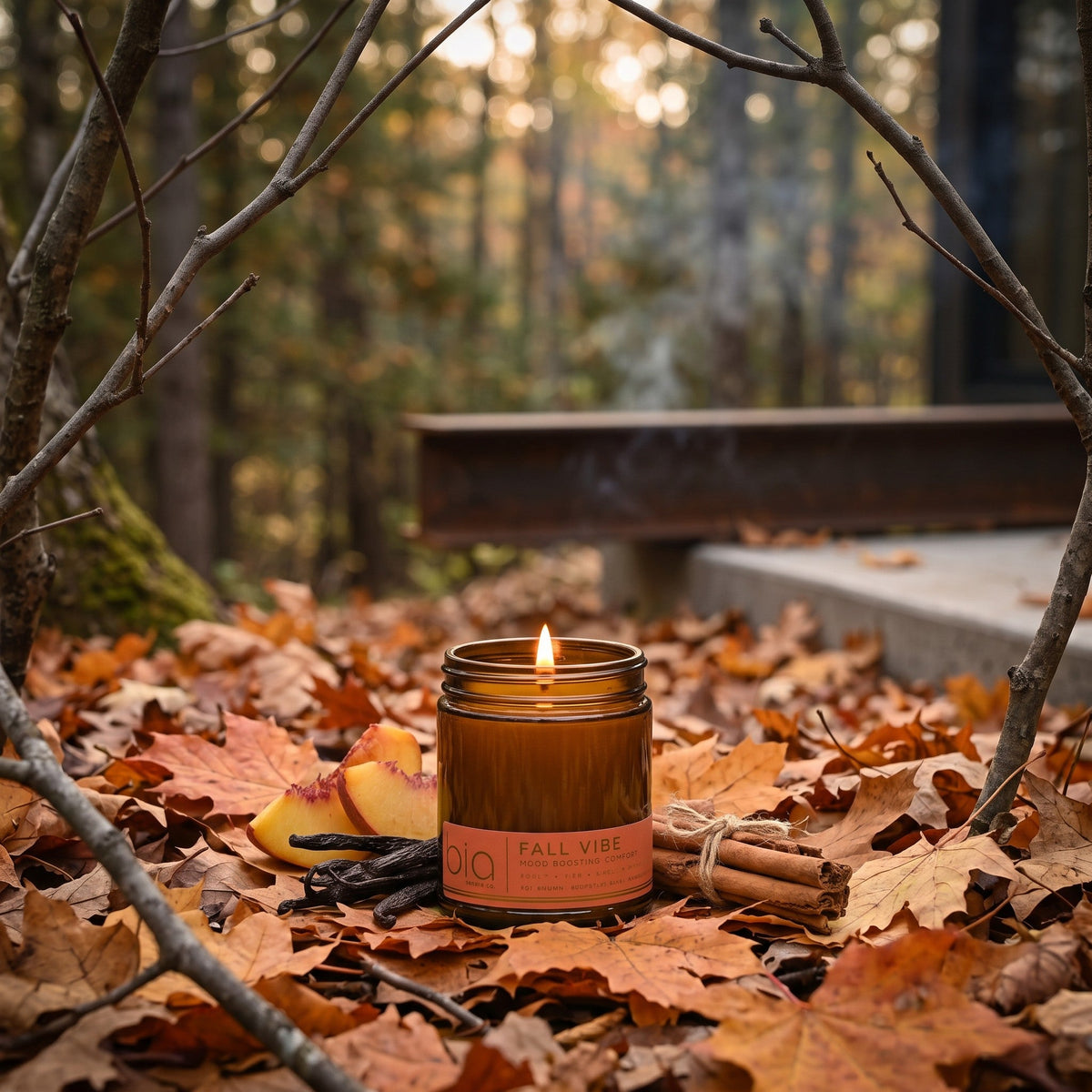 Lit Fall Vibe candle among fallen leaves in an autumn forest