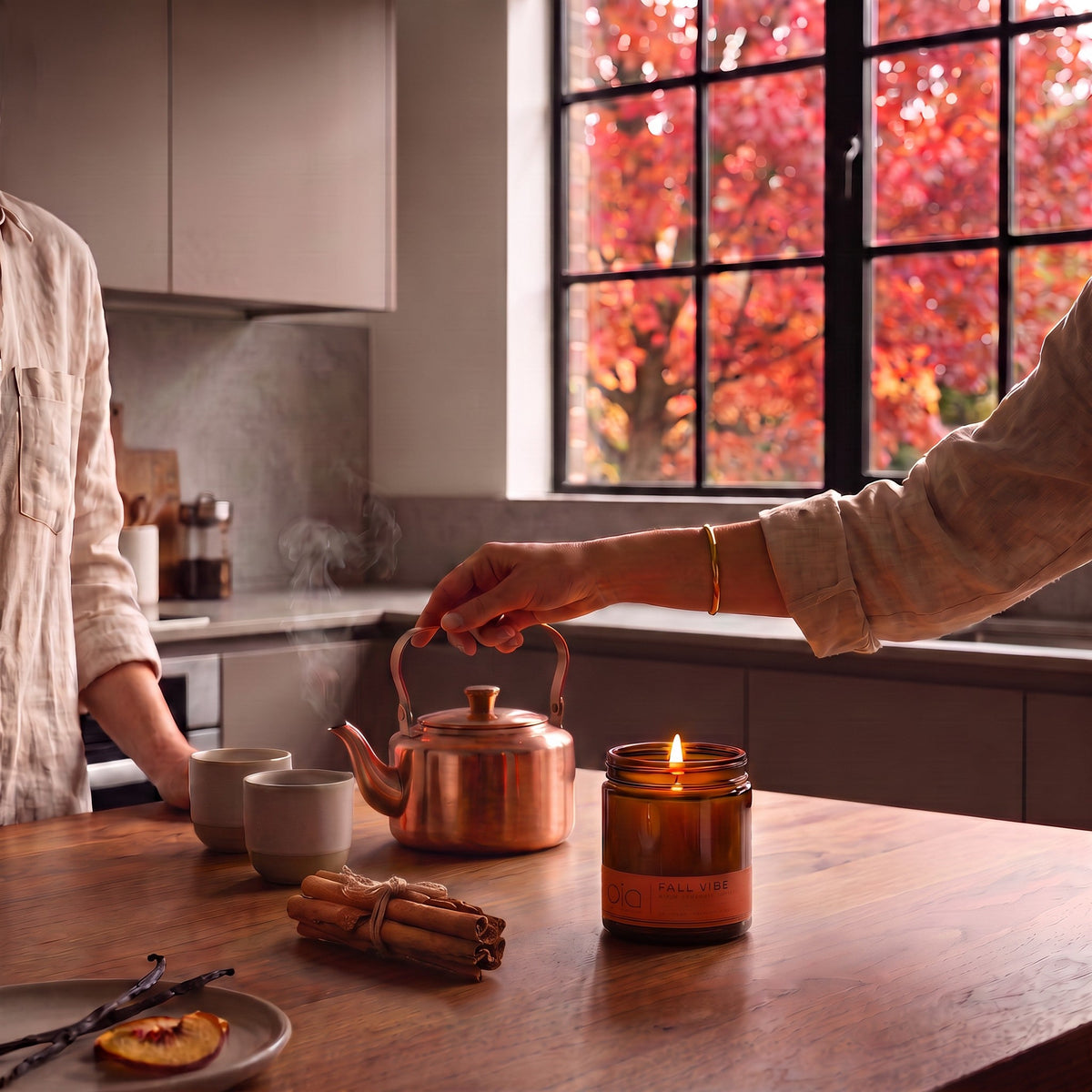 Fall Vibe candle burning on a kitchen counter beside a copper kettle and teacups