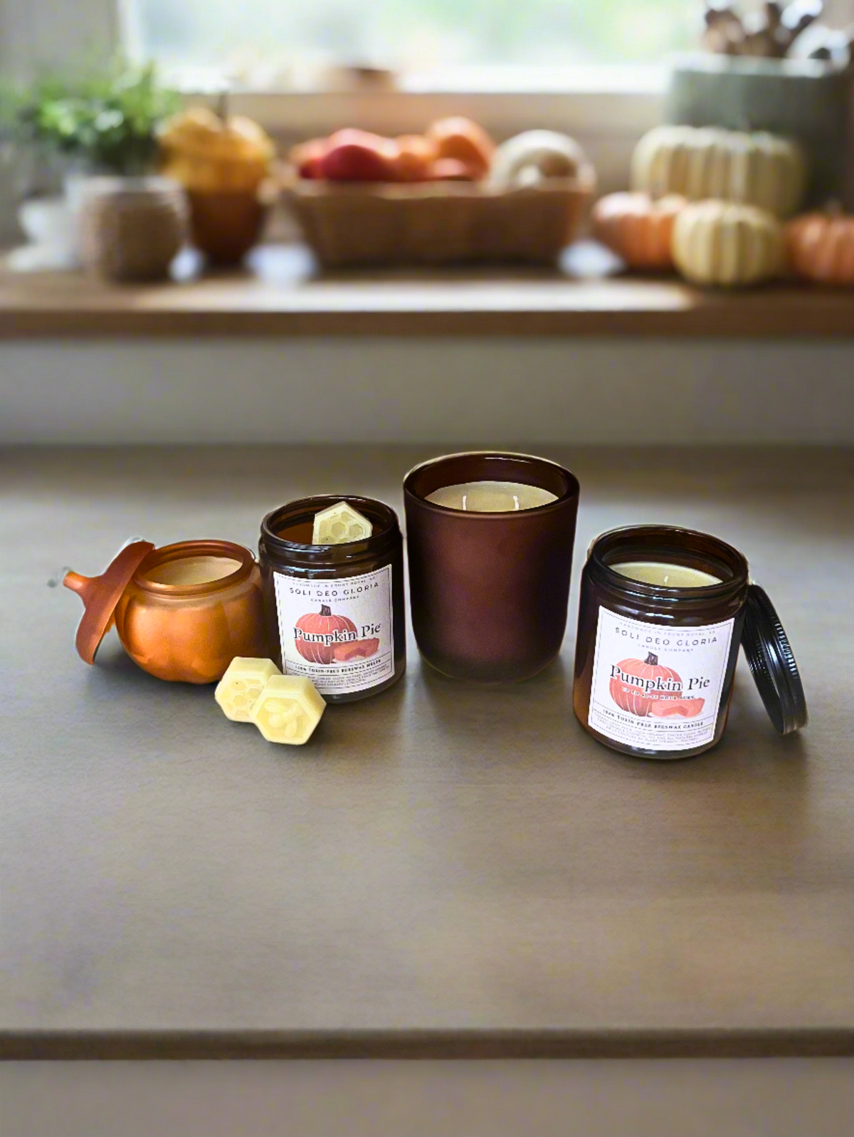 Pumpkin Pie beeswax candles on a kitchen counter with small pumpkins