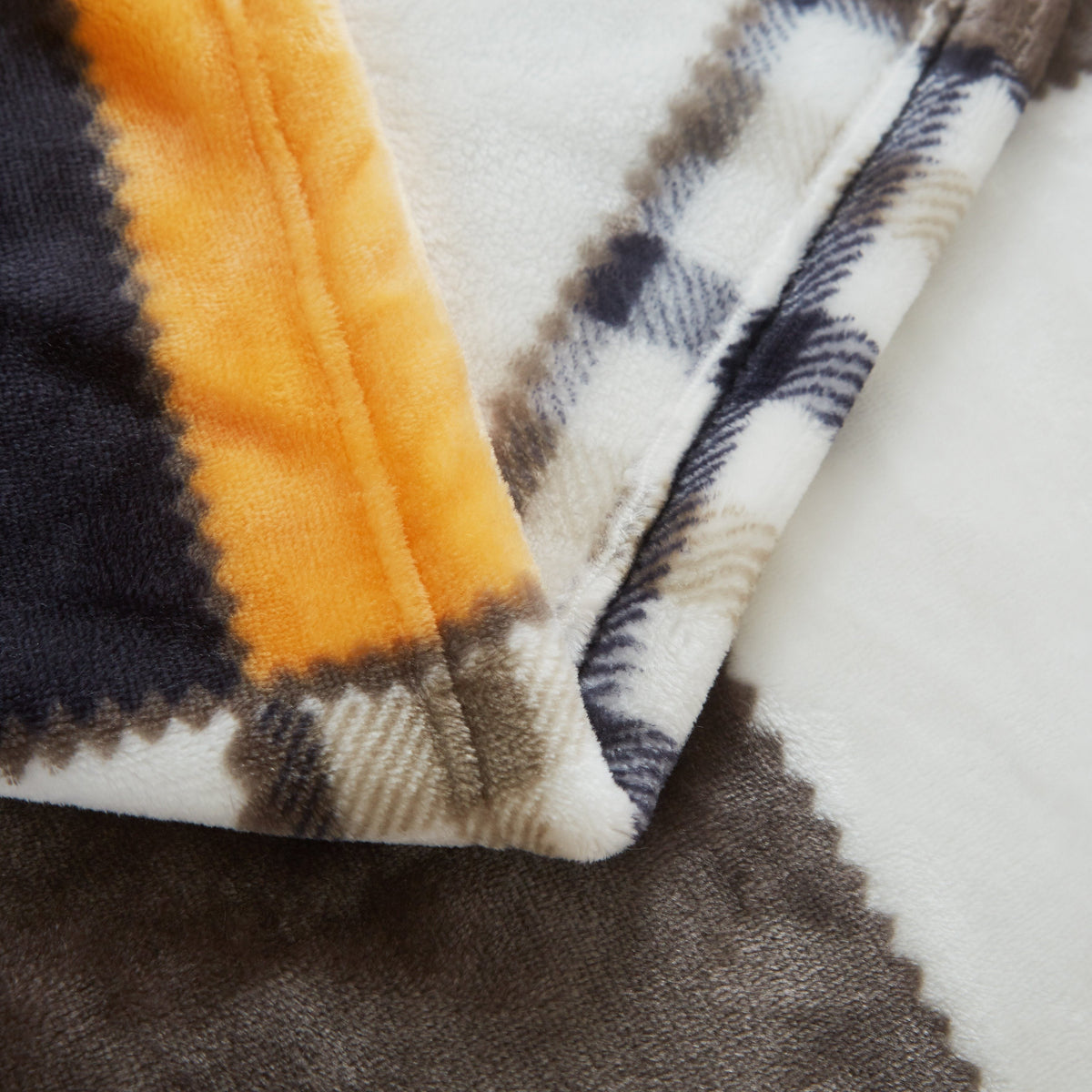 Close-up of the soft fleece and stitched edge of the patchwork throw
