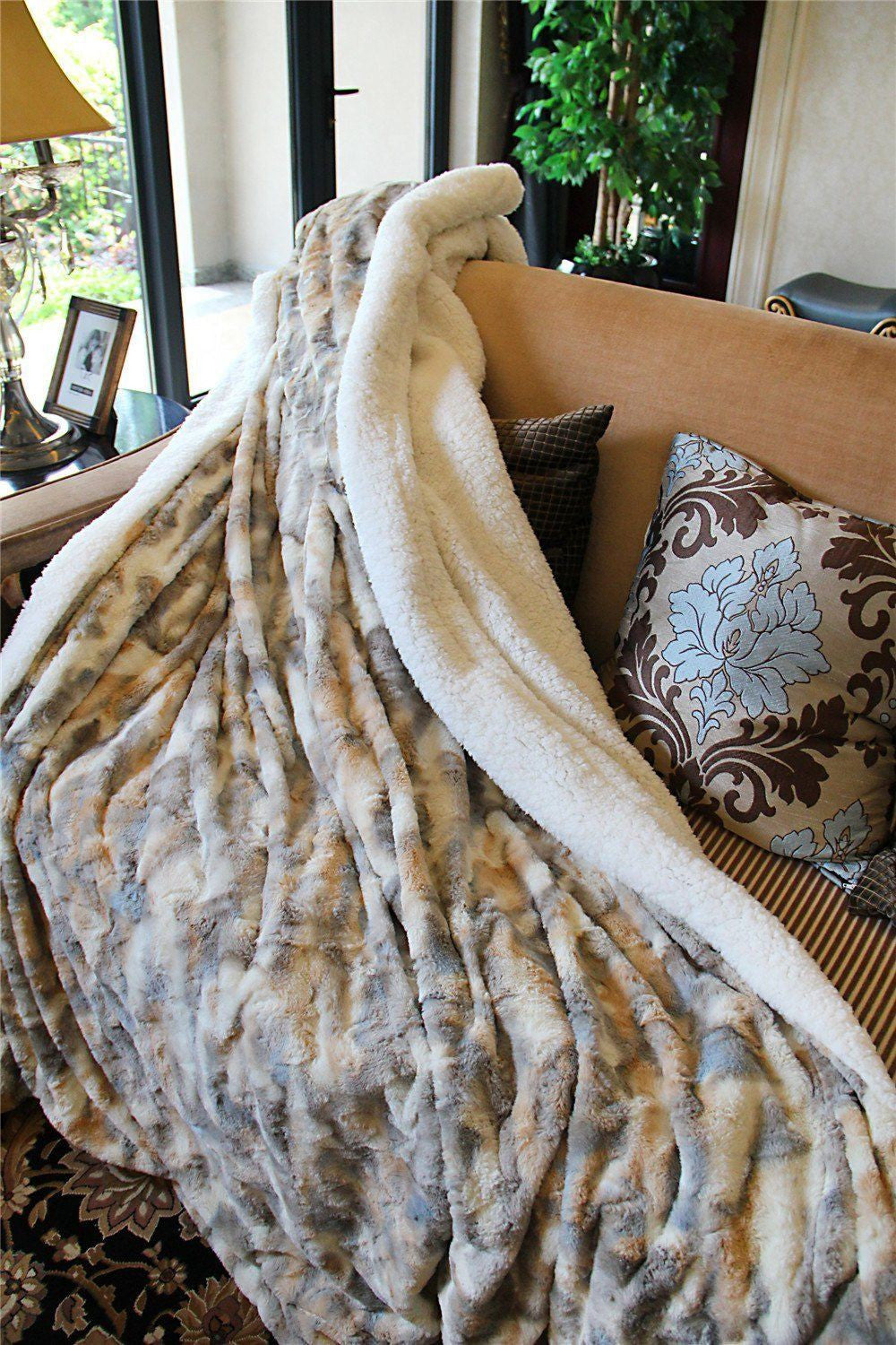Russian Lynx throw draped over a sofa with the white sherpa side folded back