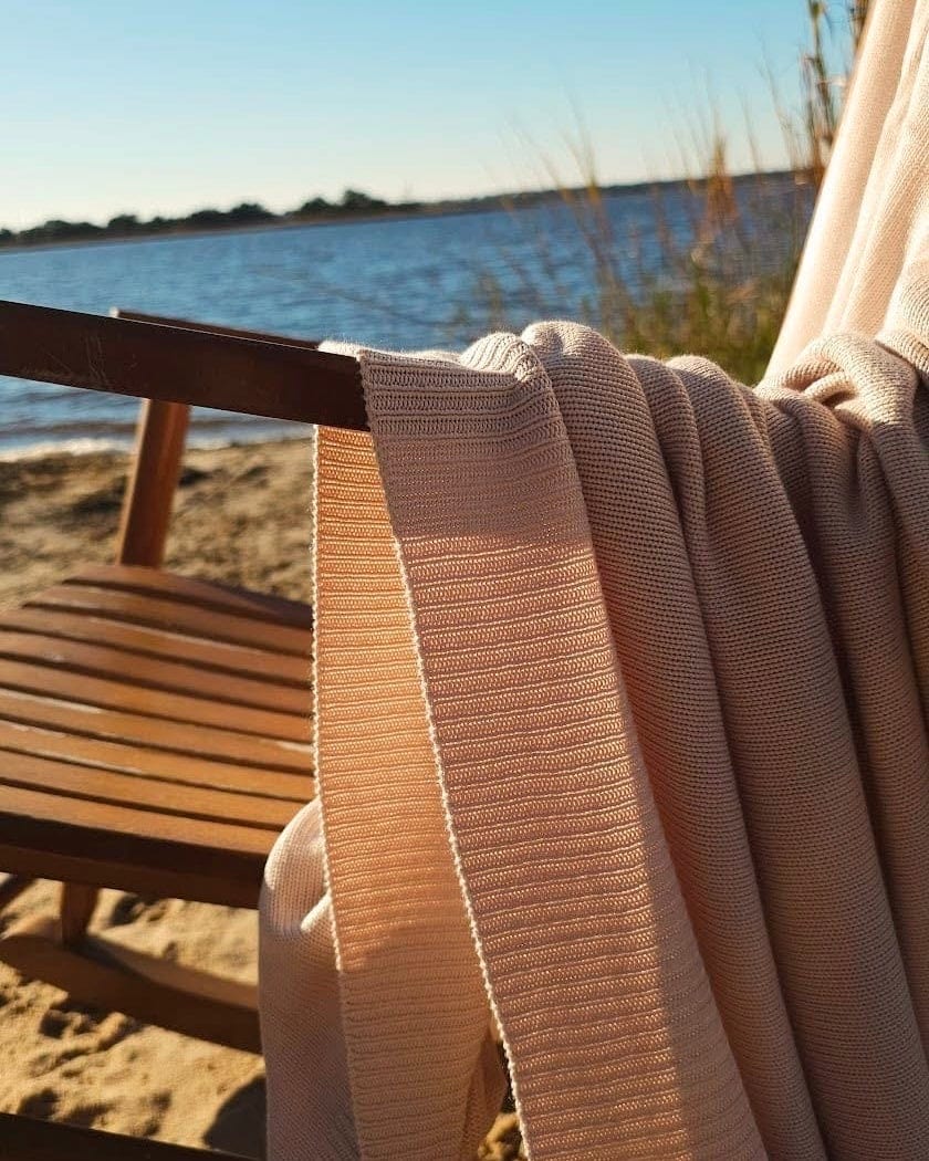 Classic Drift throw draped over a wooden chair by the water