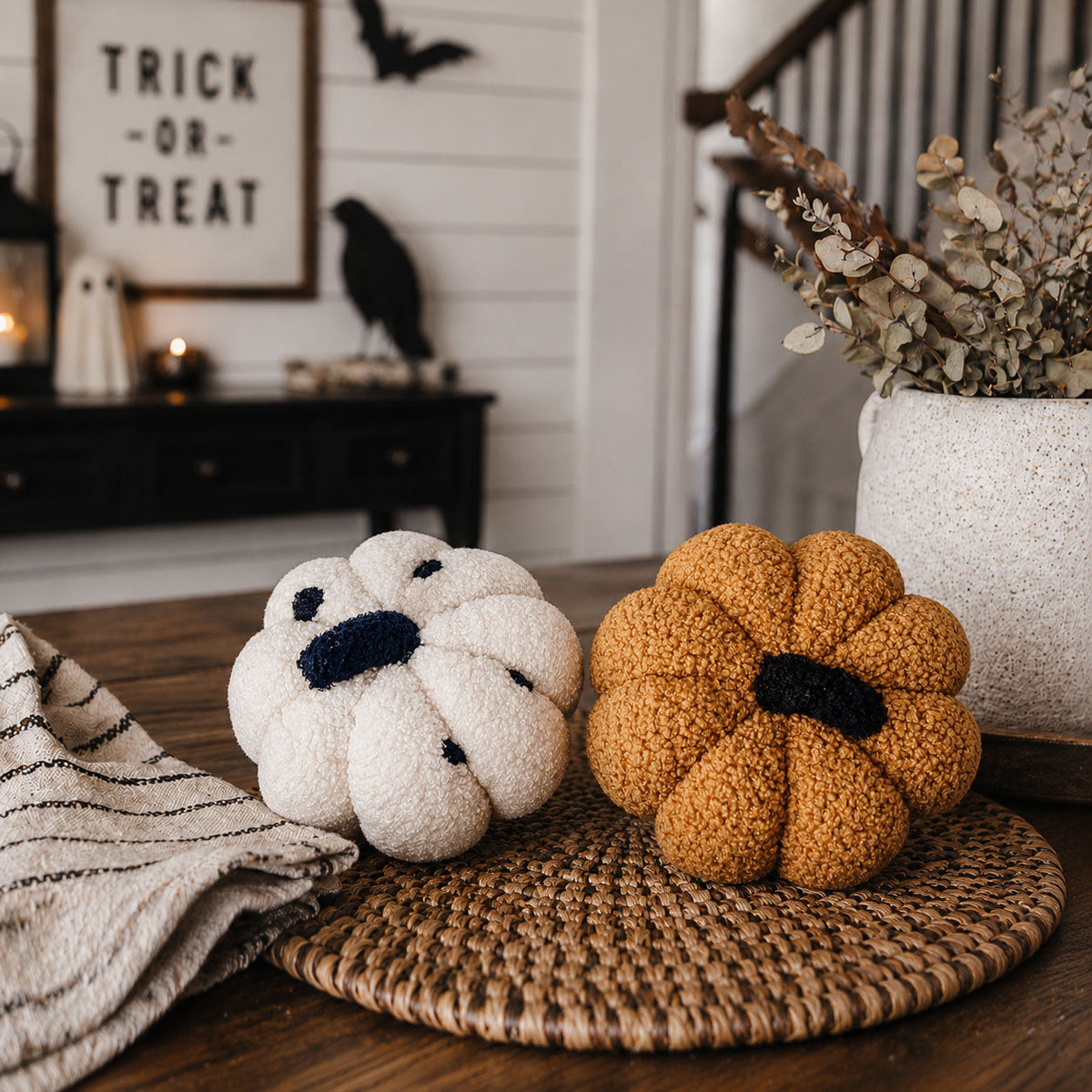 White and gold plush pumpkins on a table by the stairs