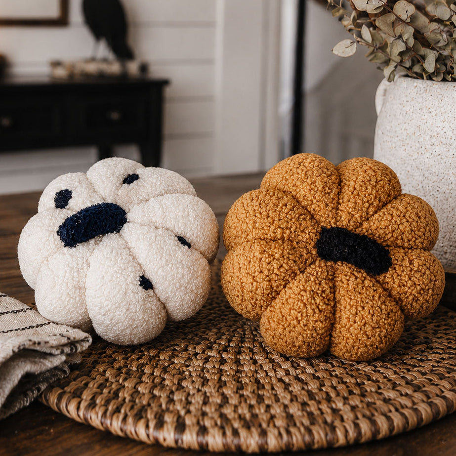 White and gold plush pumpkins on a woven placemat