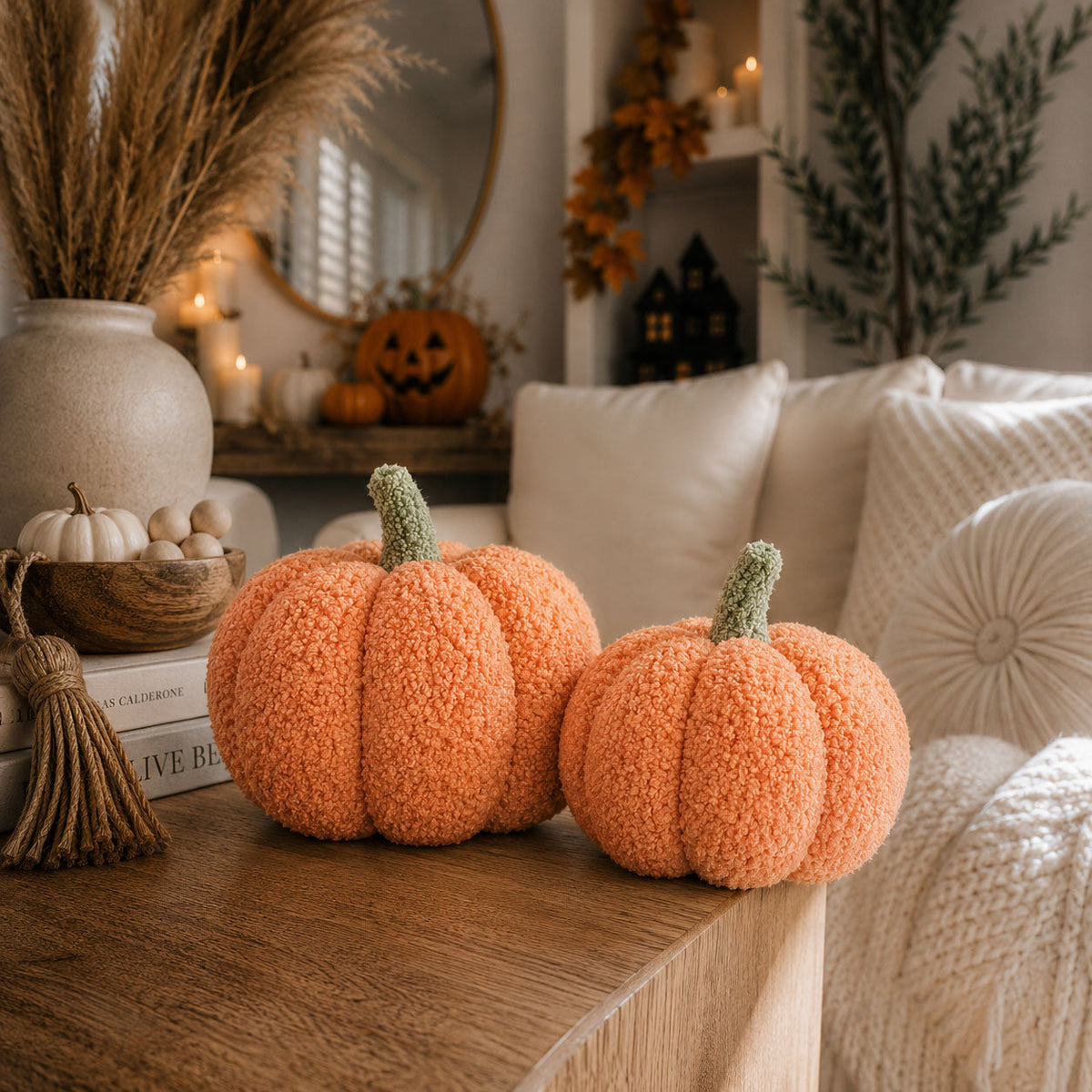 Two orange plush pumpkins on a coffee table in a cozy living room