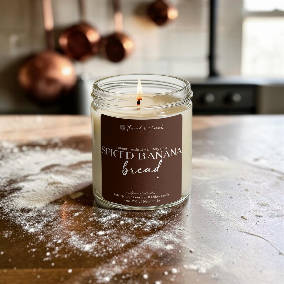 Spiced Banana Bread candle on a floured kitchen counter with copper pans behind